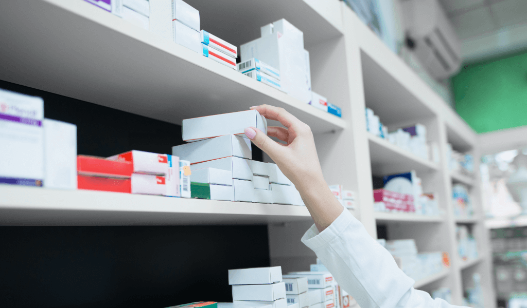 closeup-view-pharmacist-hand-taking-medicine-box-from-shelf-drug-store
