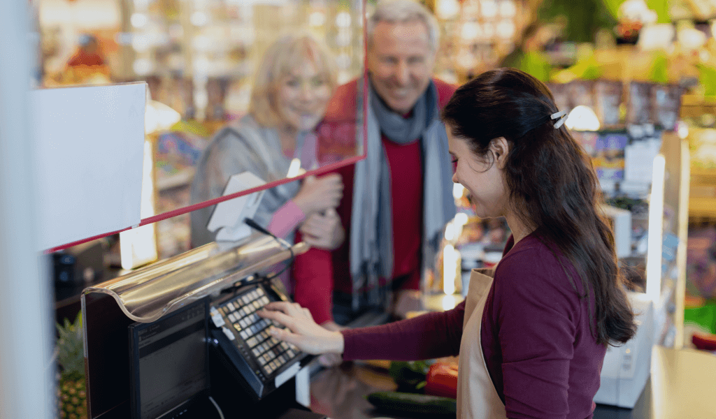 friendly-senior-husband-wife-having-conversation-with-cashier