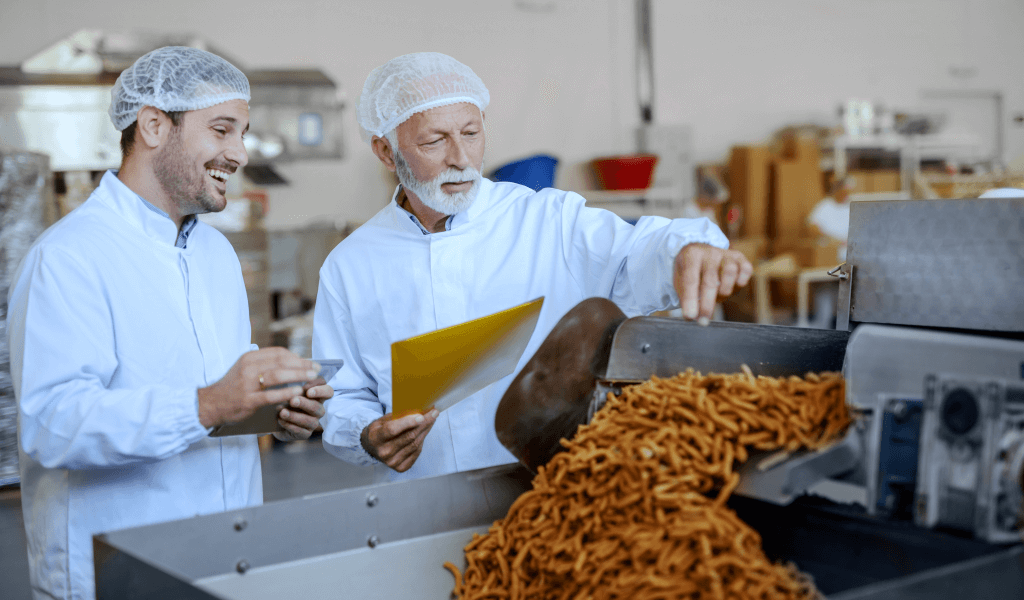 two-focused-inspectors-white-uniforms-hairnets-evaluating-quality-food-both-are-dressed-white-uniforms-having-hairnets-food-plant-interior